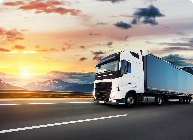 Truck traveling under colorful evening sky